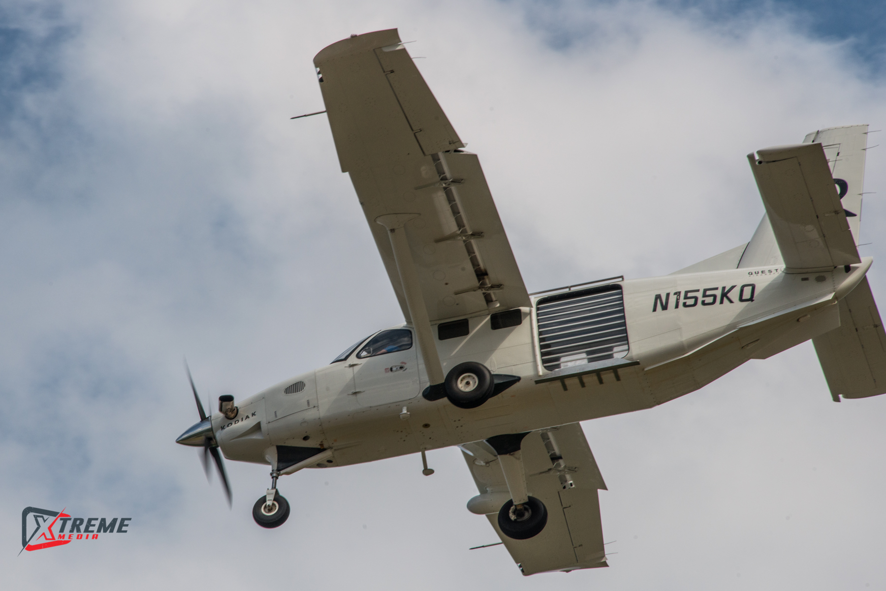 A white Kodiak skydiving jump plane flying through the sky